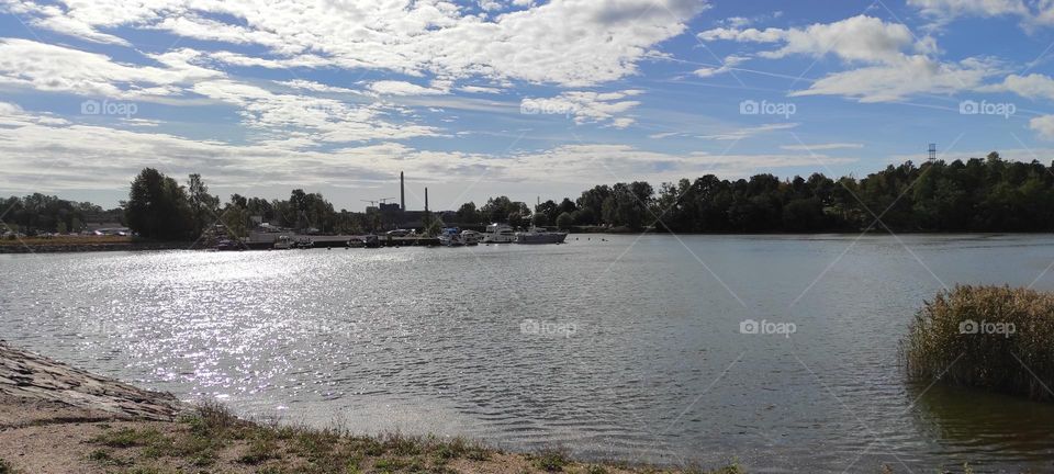 Lake with a boat harbour and a cloudy sky