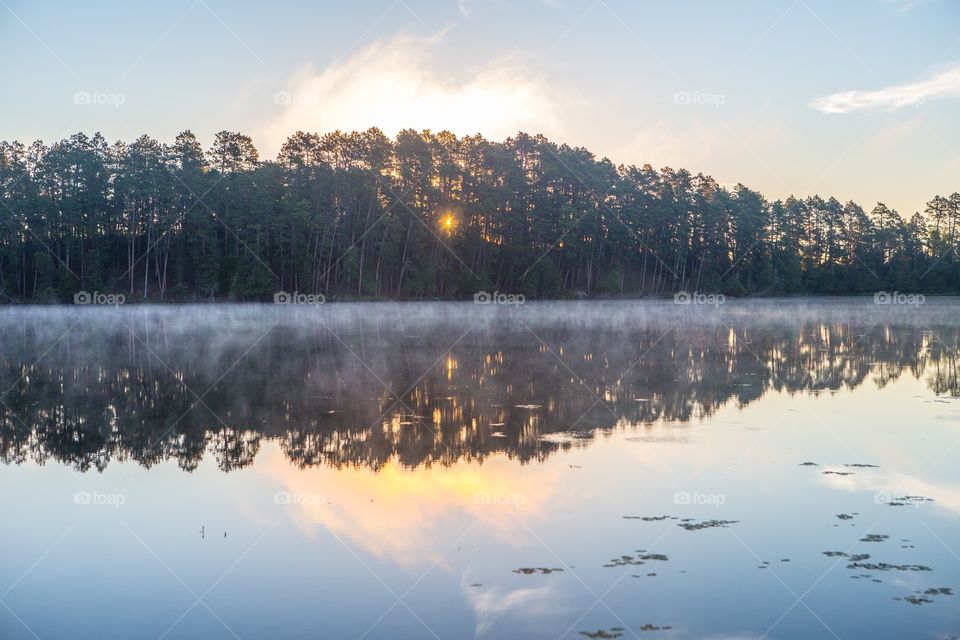 Sunrise over a foggy lake 