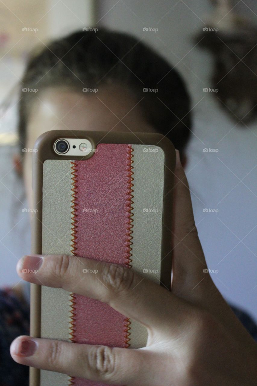 A phone with person behind taking photo