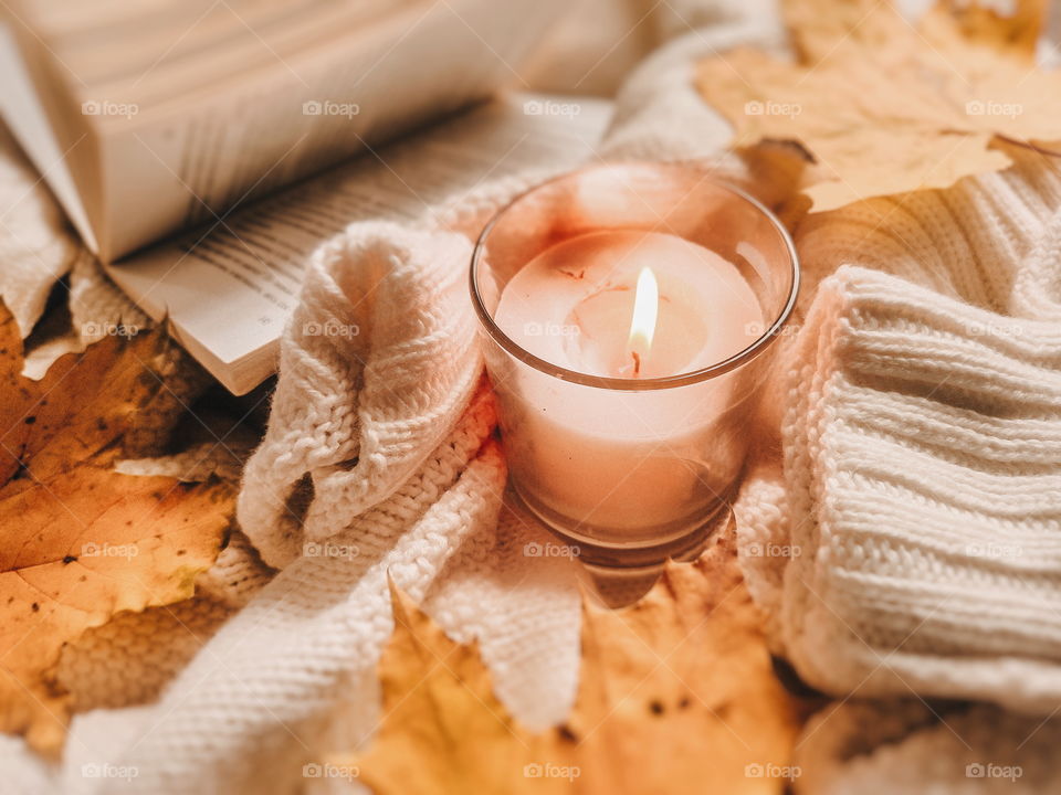 flatlay with candle, book, sweater and autumn leaves