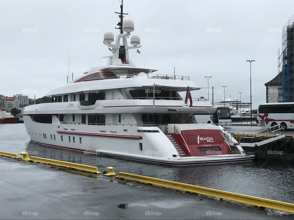 A yatch docked in Bergen. In Norway. It looks like the ship has three floors. Behind the red in the back there is a garage for cars and smaller boats..