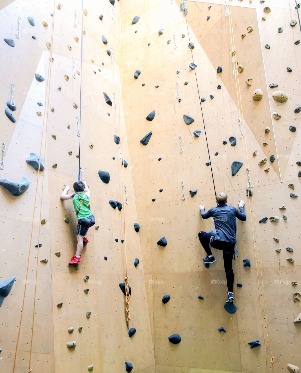 Father and son race to the top of the climbing wall at The St. James gym. 