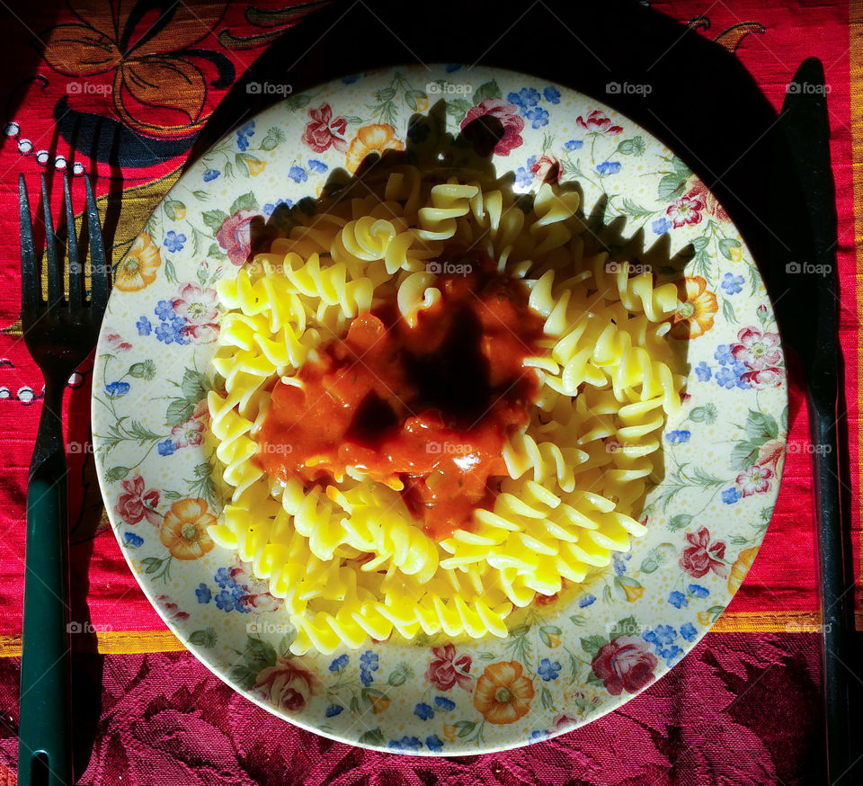 Fusilli Pasta and a sauce on a floral plate
