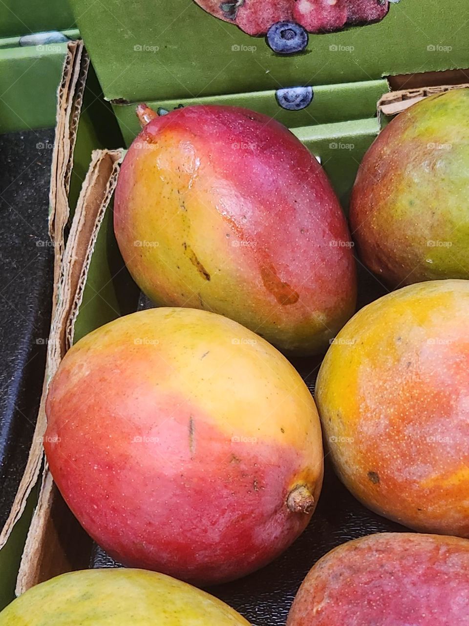 close up of colorful ripe mangoes in local market