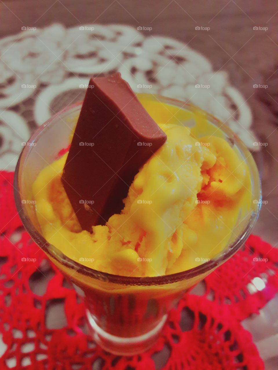 cold ice cream mango chocolate melting condensing in a glass