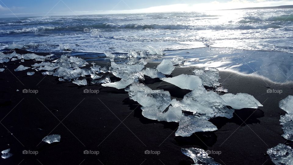 Miniature icebergs create a beautiful display against the stark contrast of a black sand beach and the Atlantic Ocean