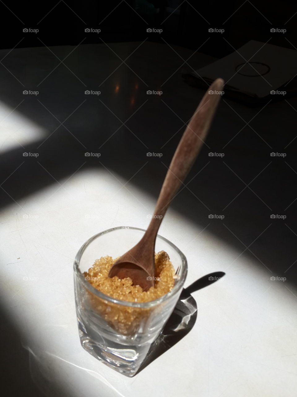brown sugar in small glass and classic wooden spoon . set
