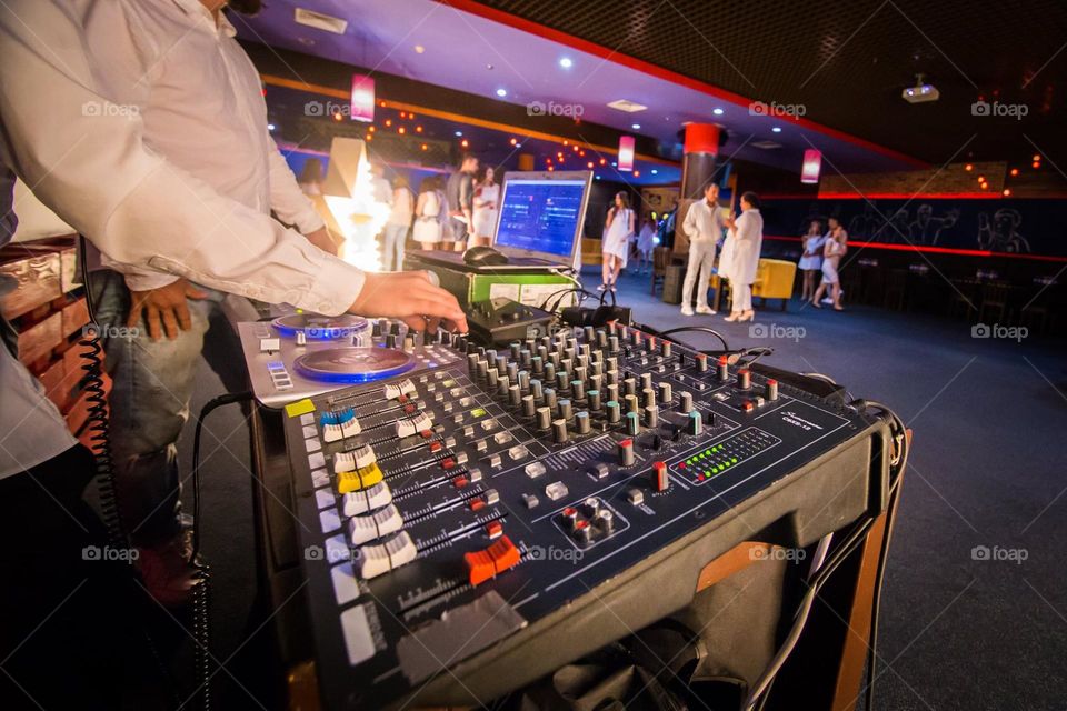 macro photo of a DJ's desktop at a party working at a DJ console with many buttons