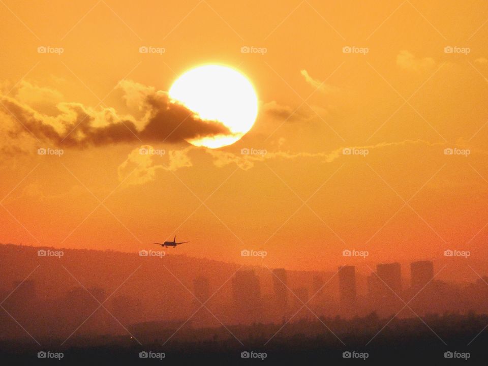 Plane flying into Honolulu at sunrise