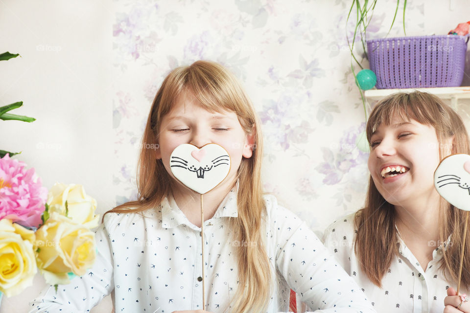 a girl with a gingerbread in the form of a hare's face and the author of the girl laughs