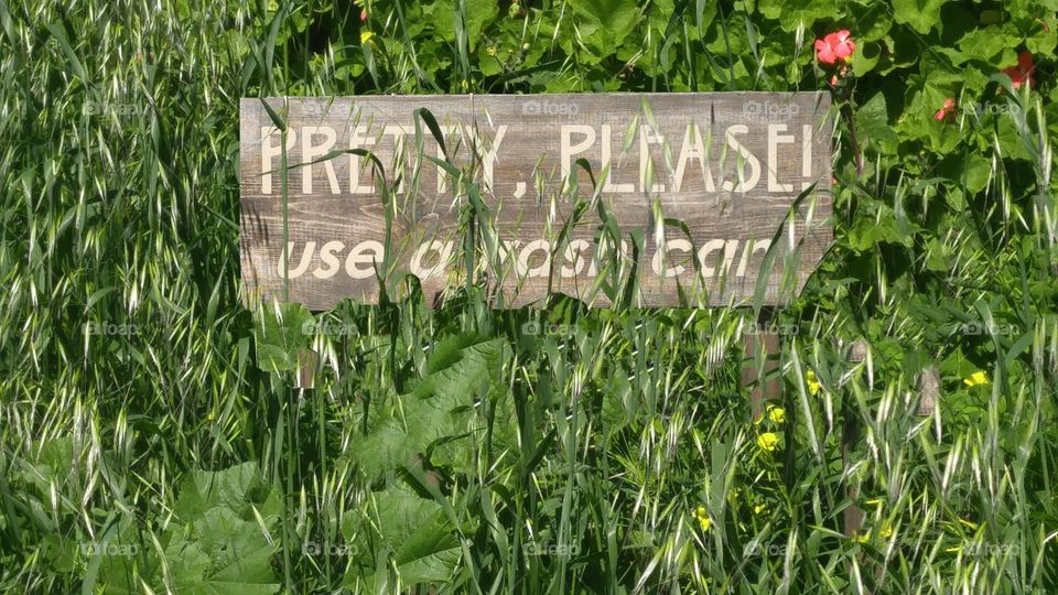 A sign that says "Pretty please use a trash can"
