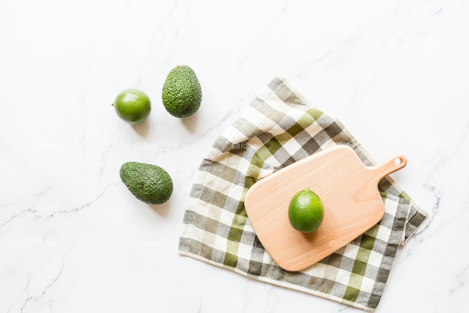 Flat lay with fresh avocado and lime 