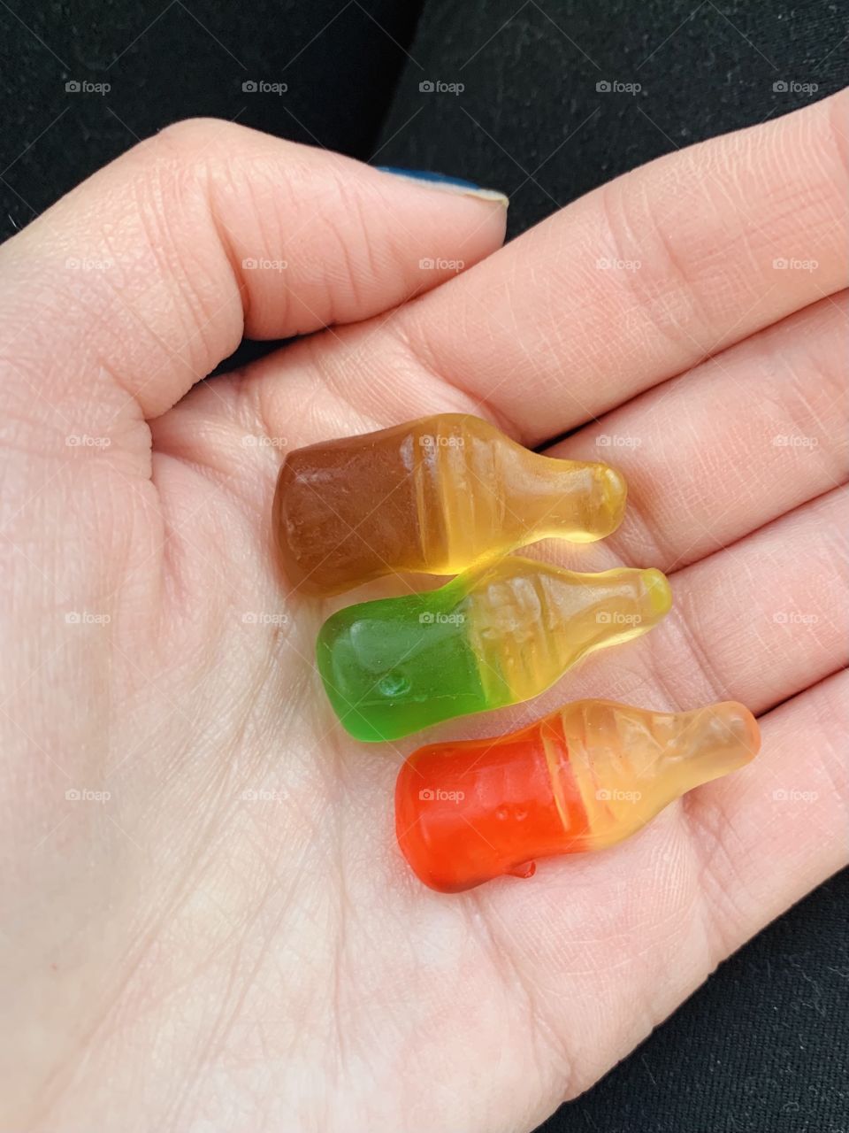 Holding sugary and sweet gummy bottle candies in hand for the long road trip 