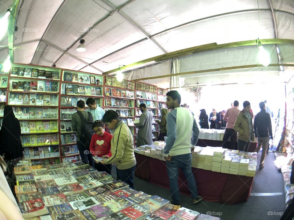 photo from the international book fair in egypt 2 kids searching for a book to buy 2018