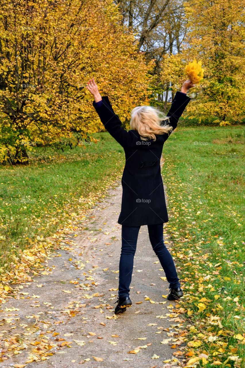 woman flying with yellow leaves nature lover autumn landscape in the park