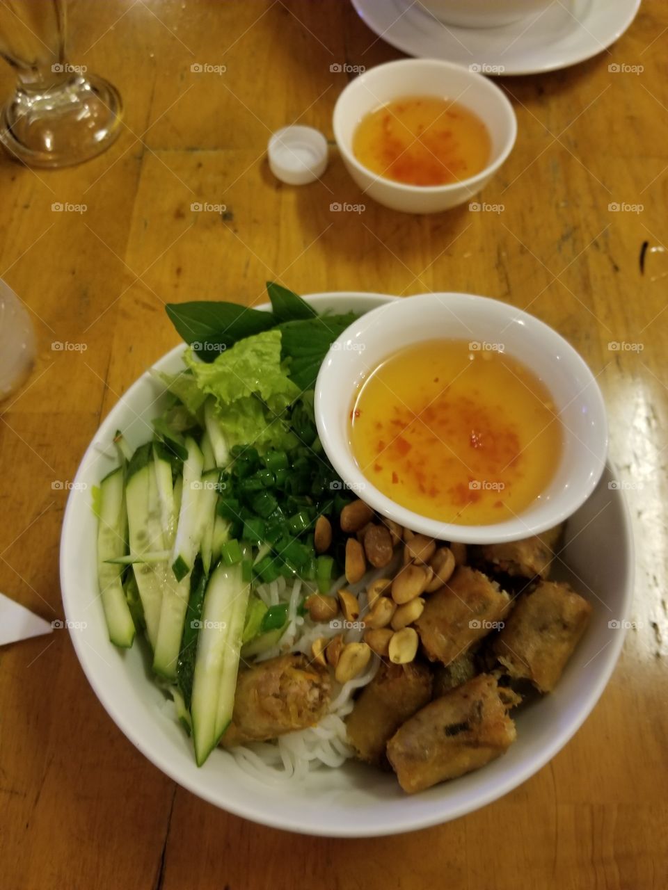 It is the famous Vietnamese Cold Vermicelli. It is served with fish sauce, garlic, spring rolls, cucumber, nuts, lemon grass and vermicelli.