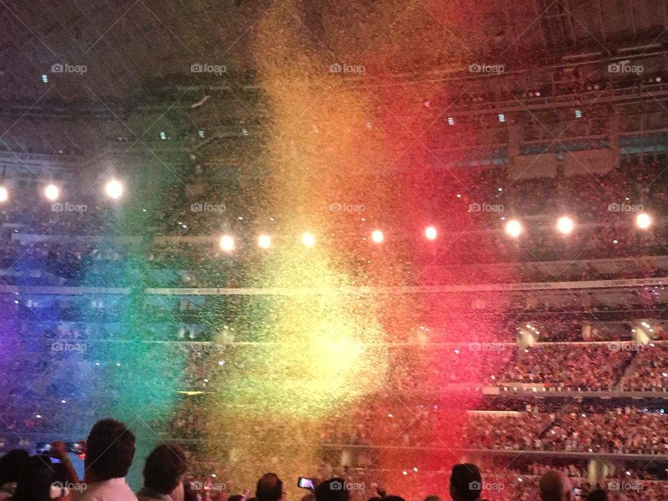 Rainbow confetti follows Chris Martin at the Dallas, Texas Coldplay concert. August 2016. 