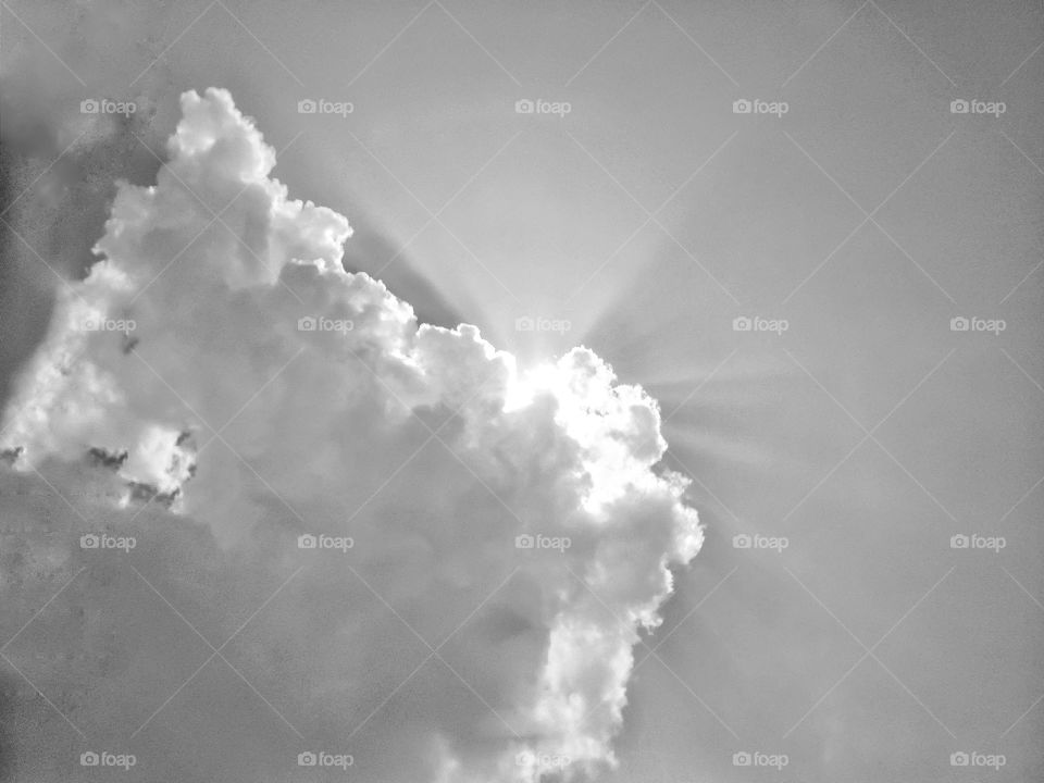 black and white sun streaks through clouds