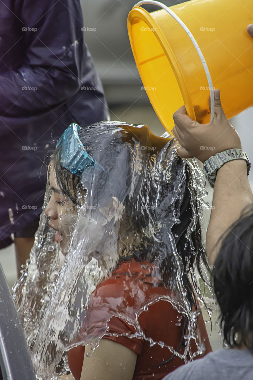 Asian woman Riding a motorcycle play water and flour in Songkran festival or Thai new year in Thailand at Bang kruai, Nonthaburi , April 15, 2019