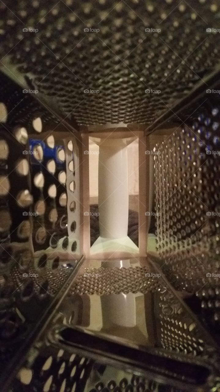 inside of a cheese grader. I was cooking baked potatoes. I needed a cheese grader. when I was reaching for a plate in my cabinet, I hit the grader. looked down,and happened to look inside the cheese grader. thought it was a cool image and took a pi