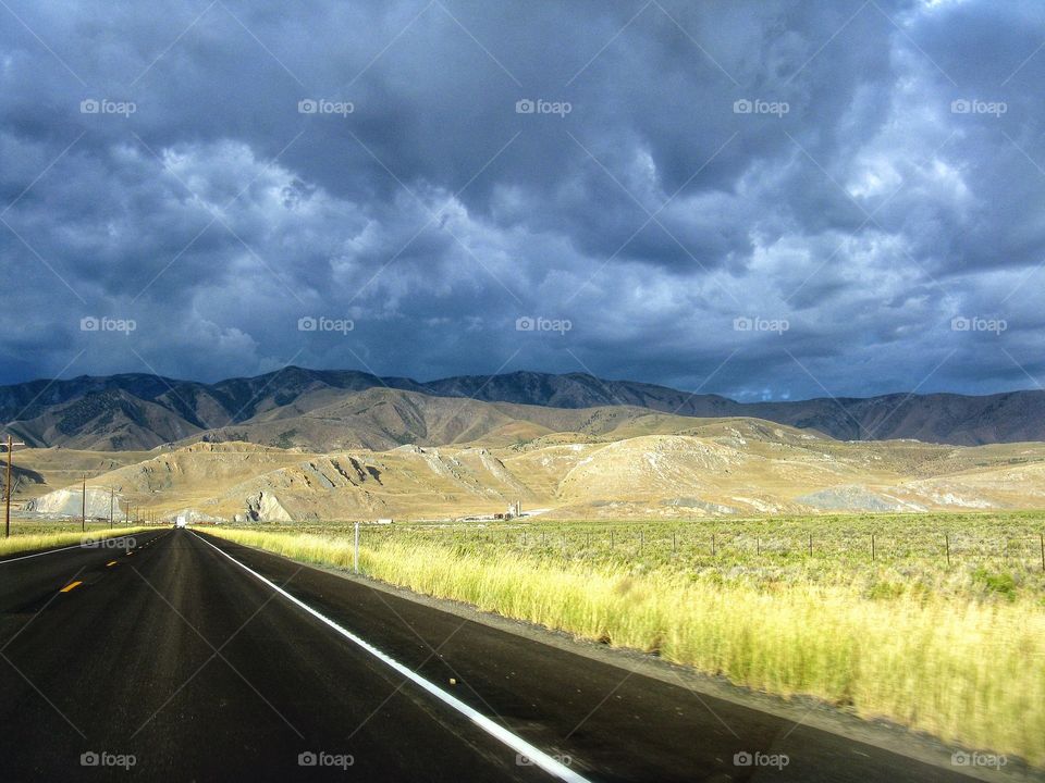 Mountain road sky. A perspective view looking down the road with amazing clouds above.