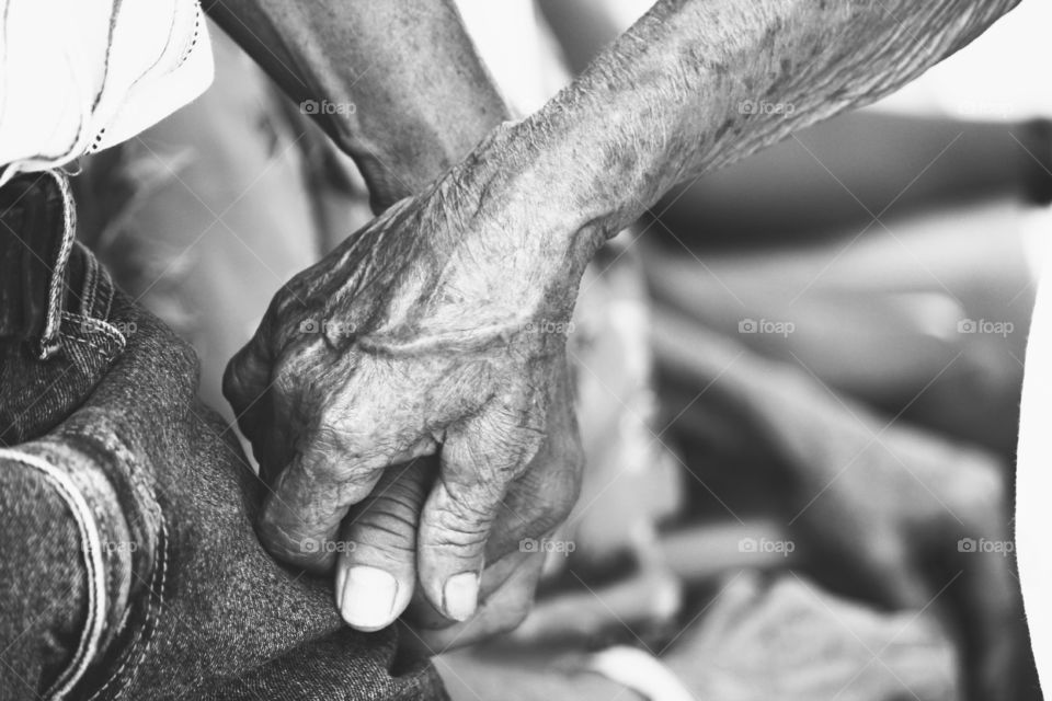 Black and white view of senior couple holding hands