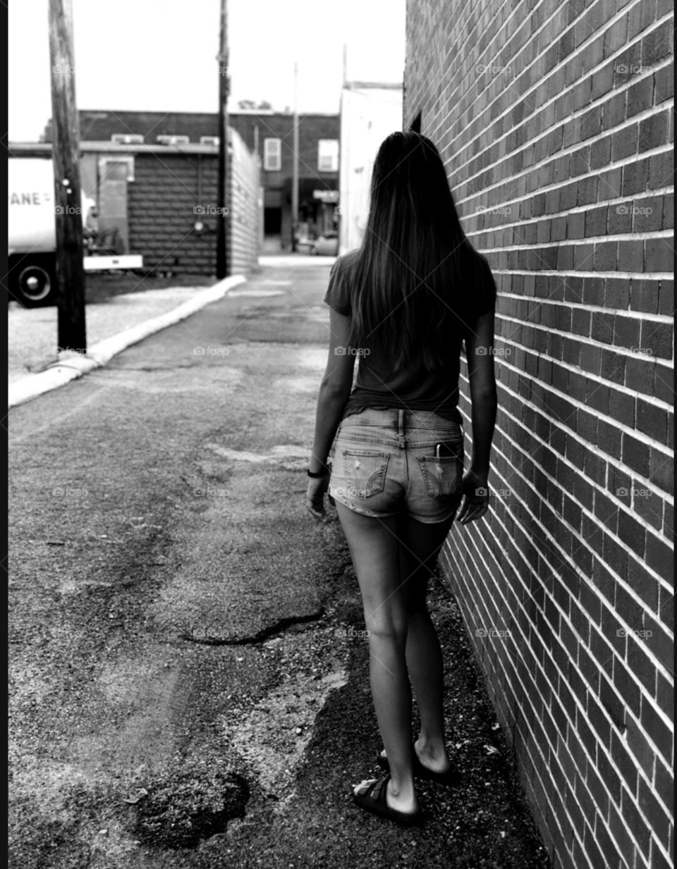 Tall girl walking through an alley