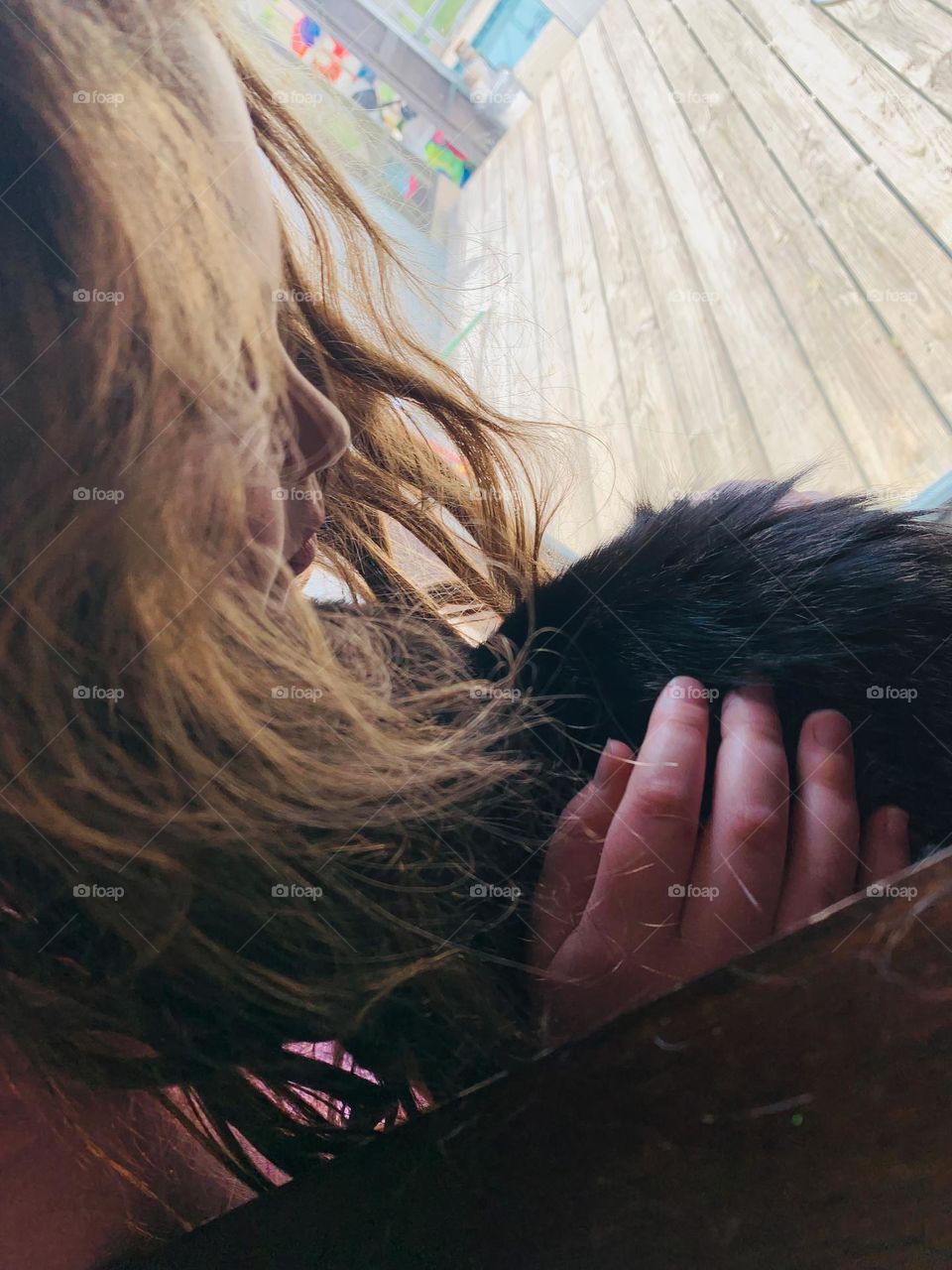 Little Girl Hugging The Kitty Cat Charlie Looking At Him In Front Of The Clear Glass Patio Door.