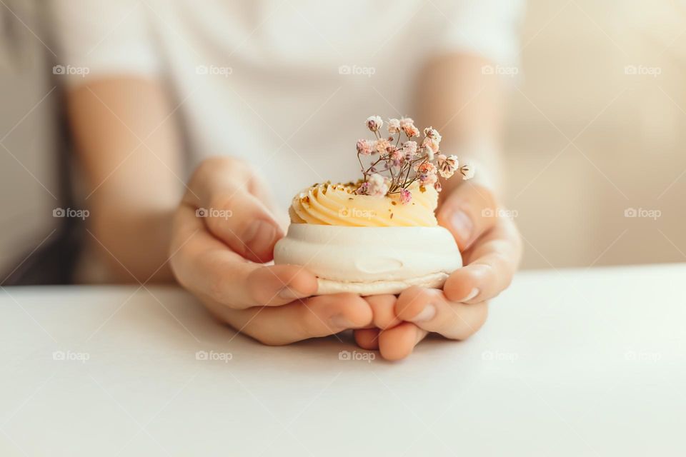 Person holding dessert pavlova.