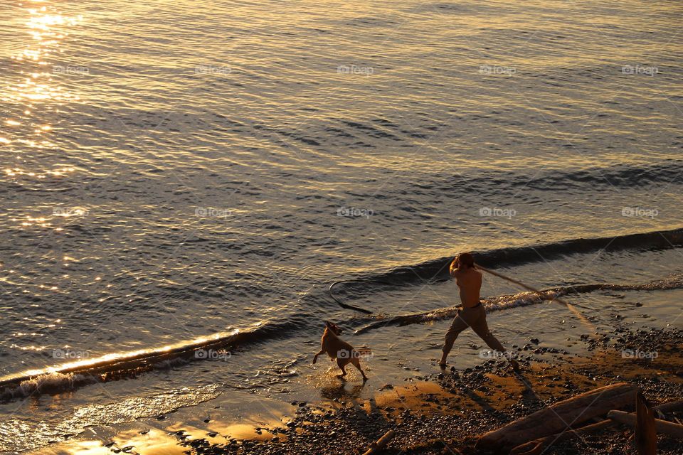 Man playing with his dog on a beach