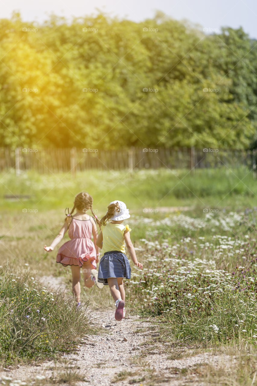 Girls running away in summer, friends having fun