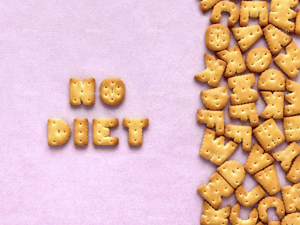 Words No diet made of crackers in the form of English alphabet letters, textured pink background