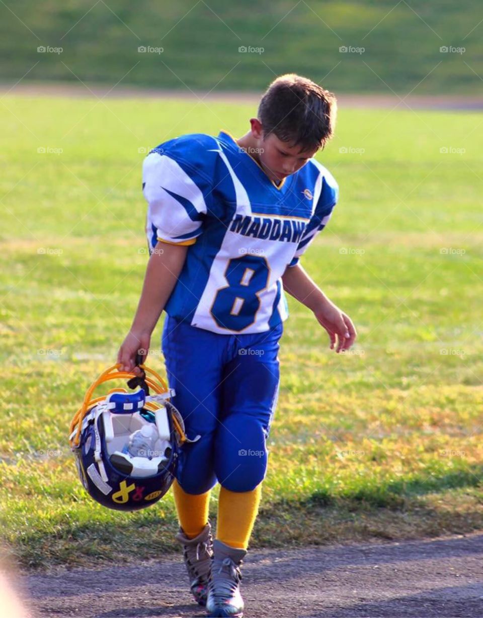 Young Athlete. Candid shot of a young man dressed in his football gear. 