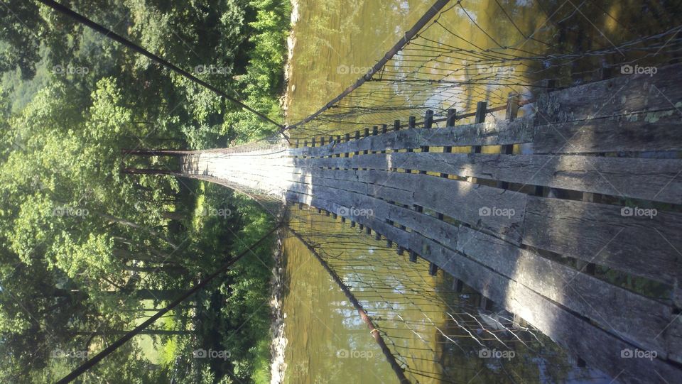 Swinging Bridge. An old, rickety swinging bridge over the beginning of the New River in West Virginia