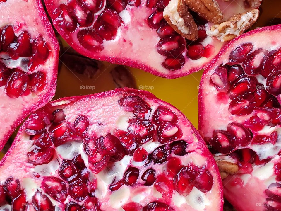 A closeup of pomegranate halves in natural light that brings out the beautiful viva magenta color.