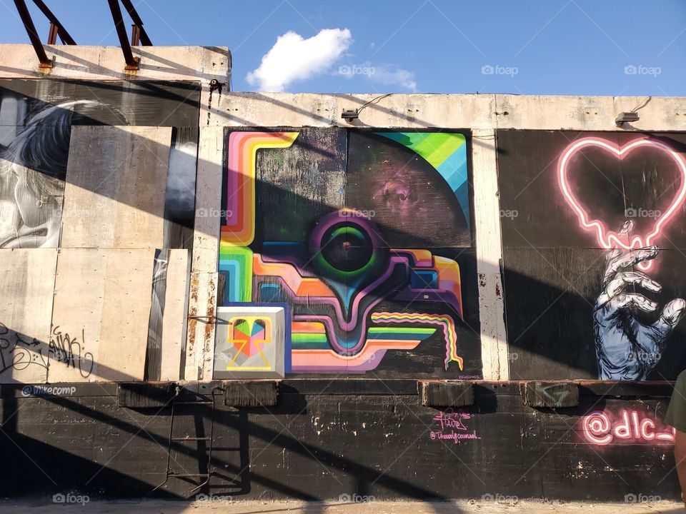 Sunset shadows across an abandoned outdoor colorful and bright mural street art gallery.