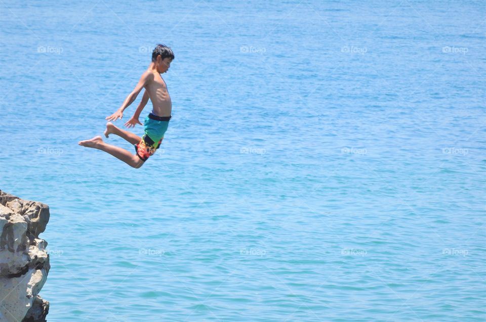 Boy jumping off the cliff