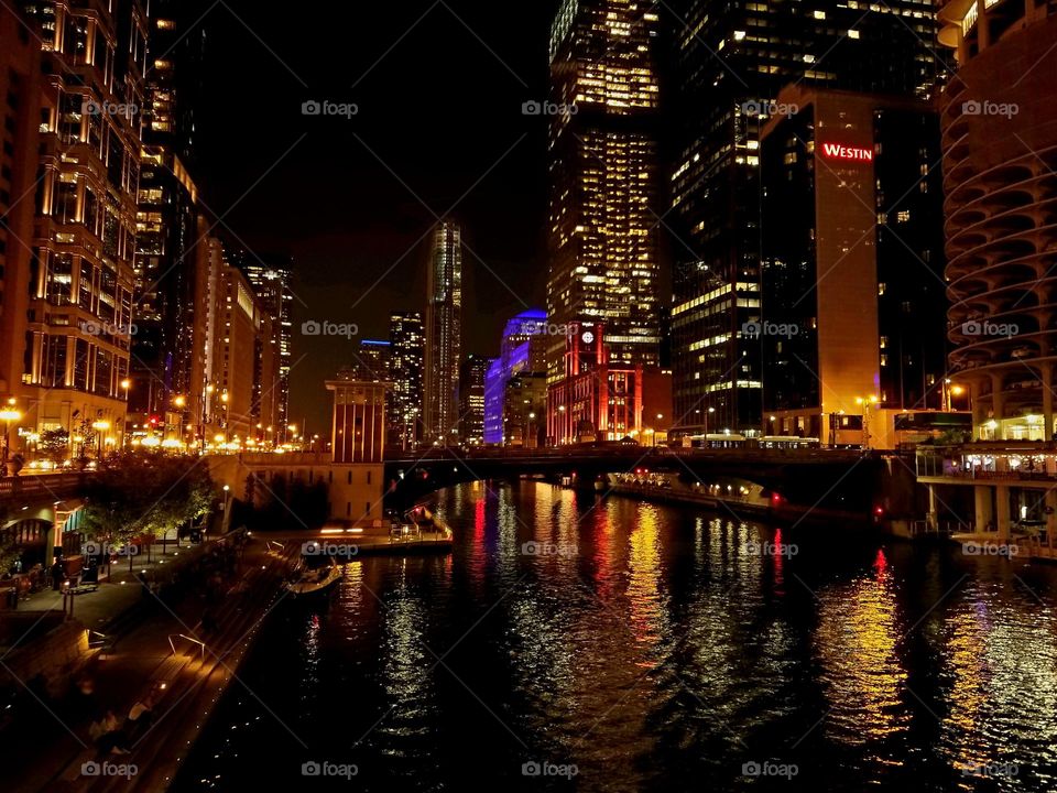 Downtown Chicago over the river on a cool night with amber lighting glowing through the space