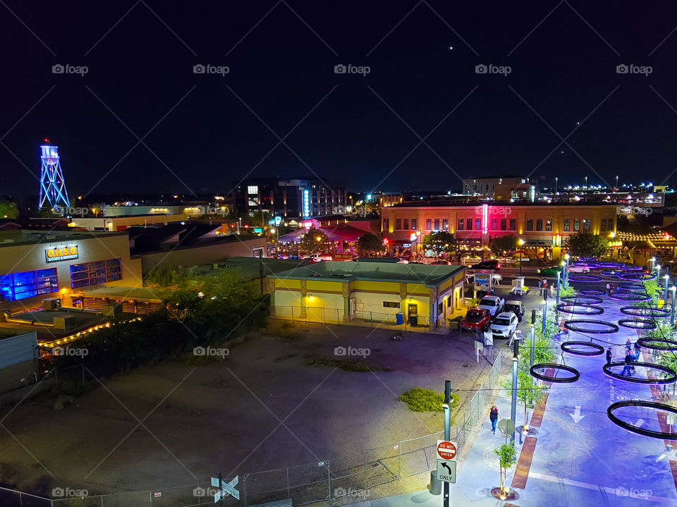 A wide shot of downtown Gilbert Arizona with the beautiful bright neon and restored water tower