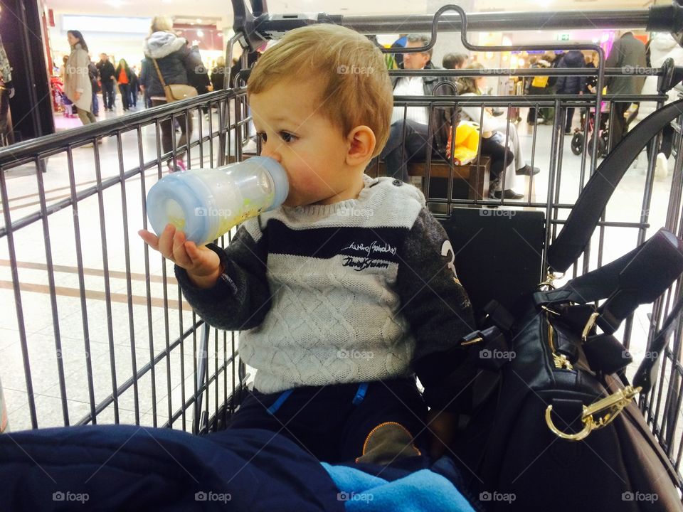 Little boy drinking with a milk bottle