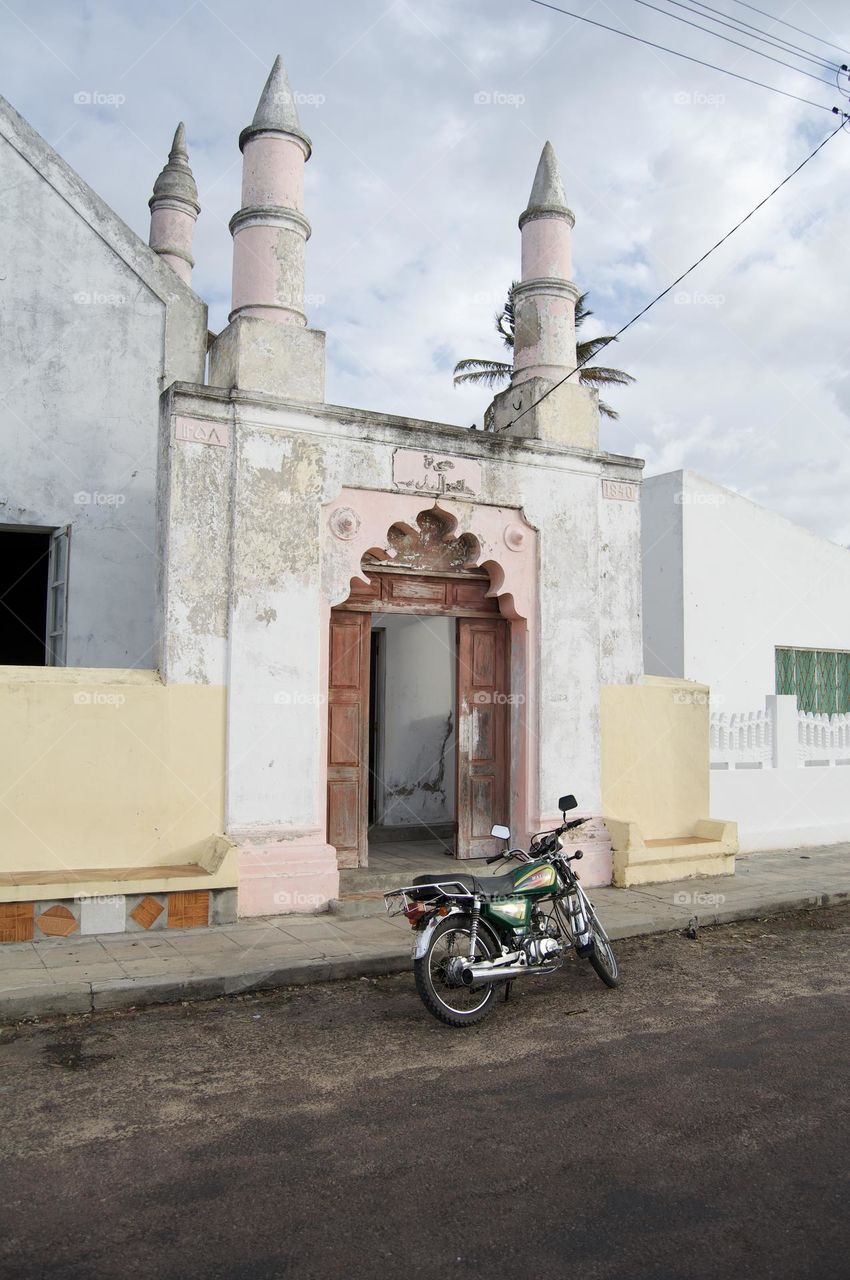 Motor bike in front of old mosque