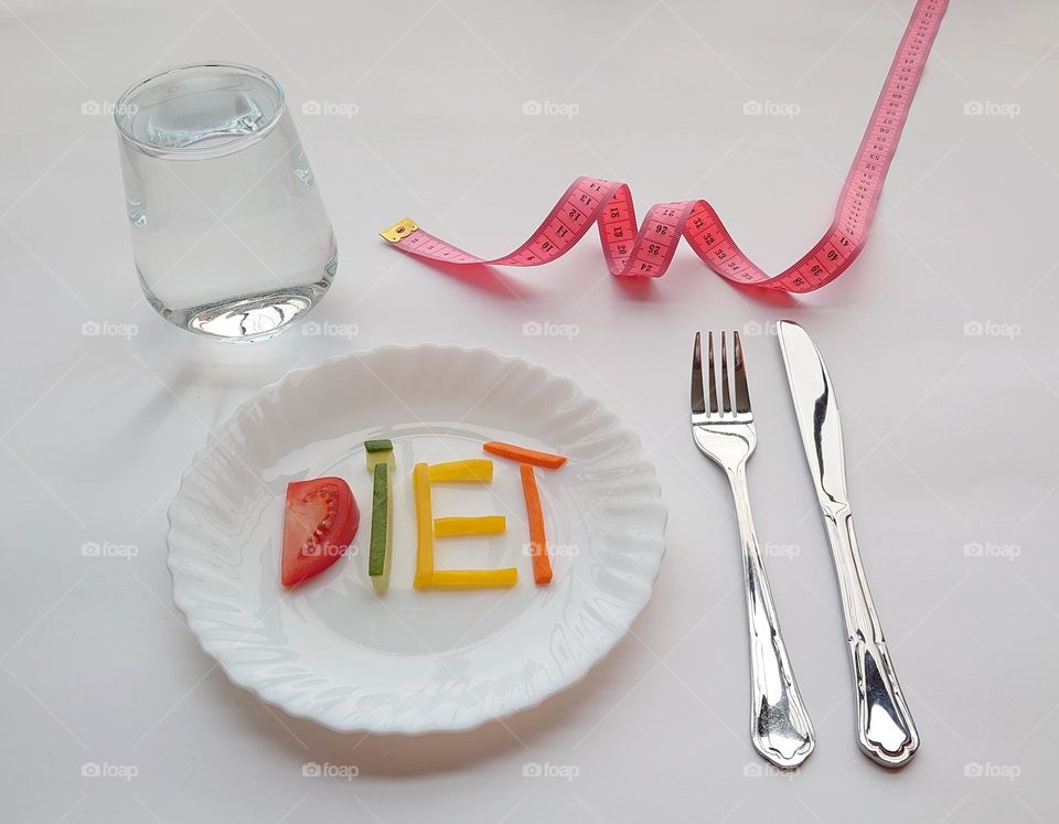 Diet plans 🍅🥕🫑🥒 A glass of water, a plate with vegetables, a measuring meter, cutlery on a white table 💧