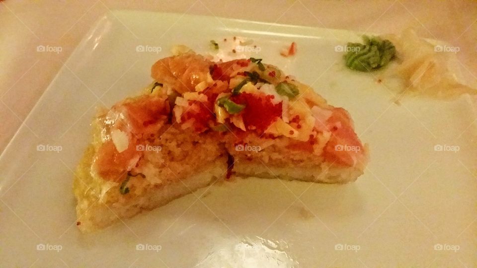 Sushi pizza with salmon, tempura, mango and caviar with wasabi and ginger on the side