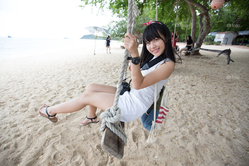 Cute girl on the swing in the beach