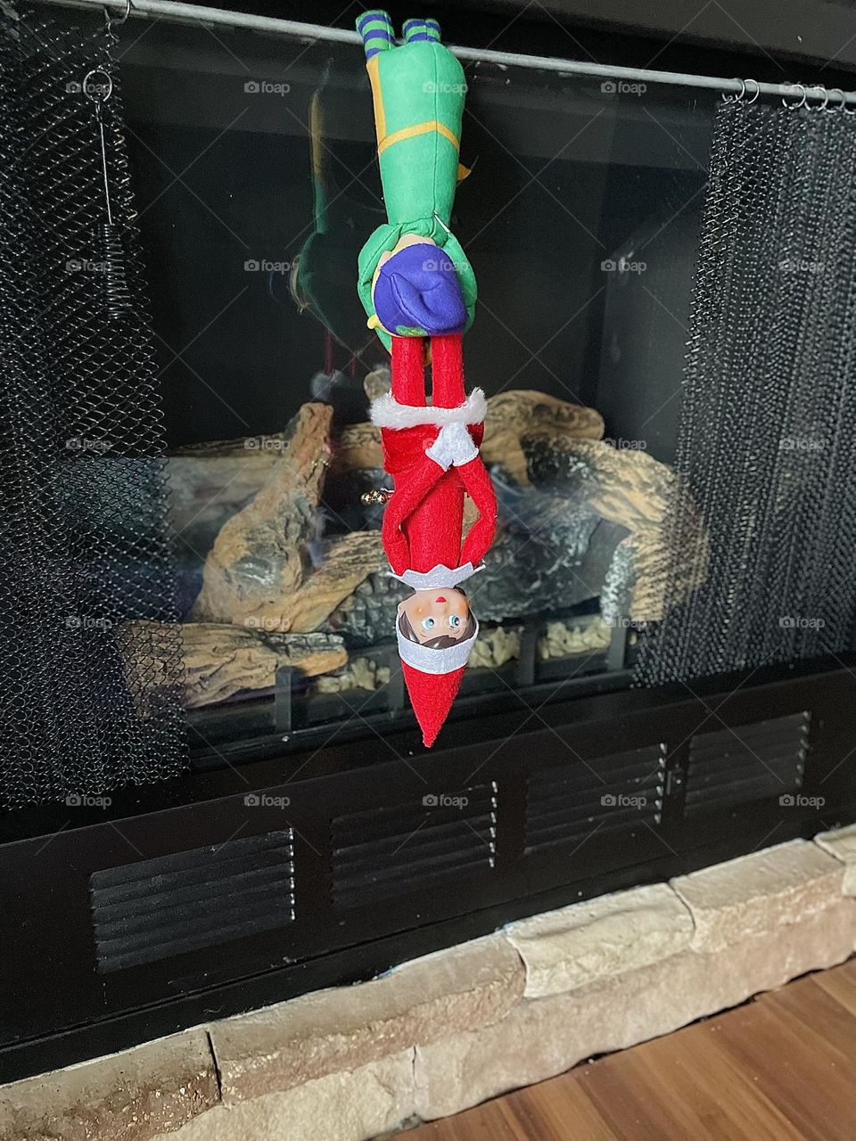 Elf on the shelf inspects fireplace for Santa, safety first for Santa, the elves work together for Santa, elf on the shelf tradition for children 