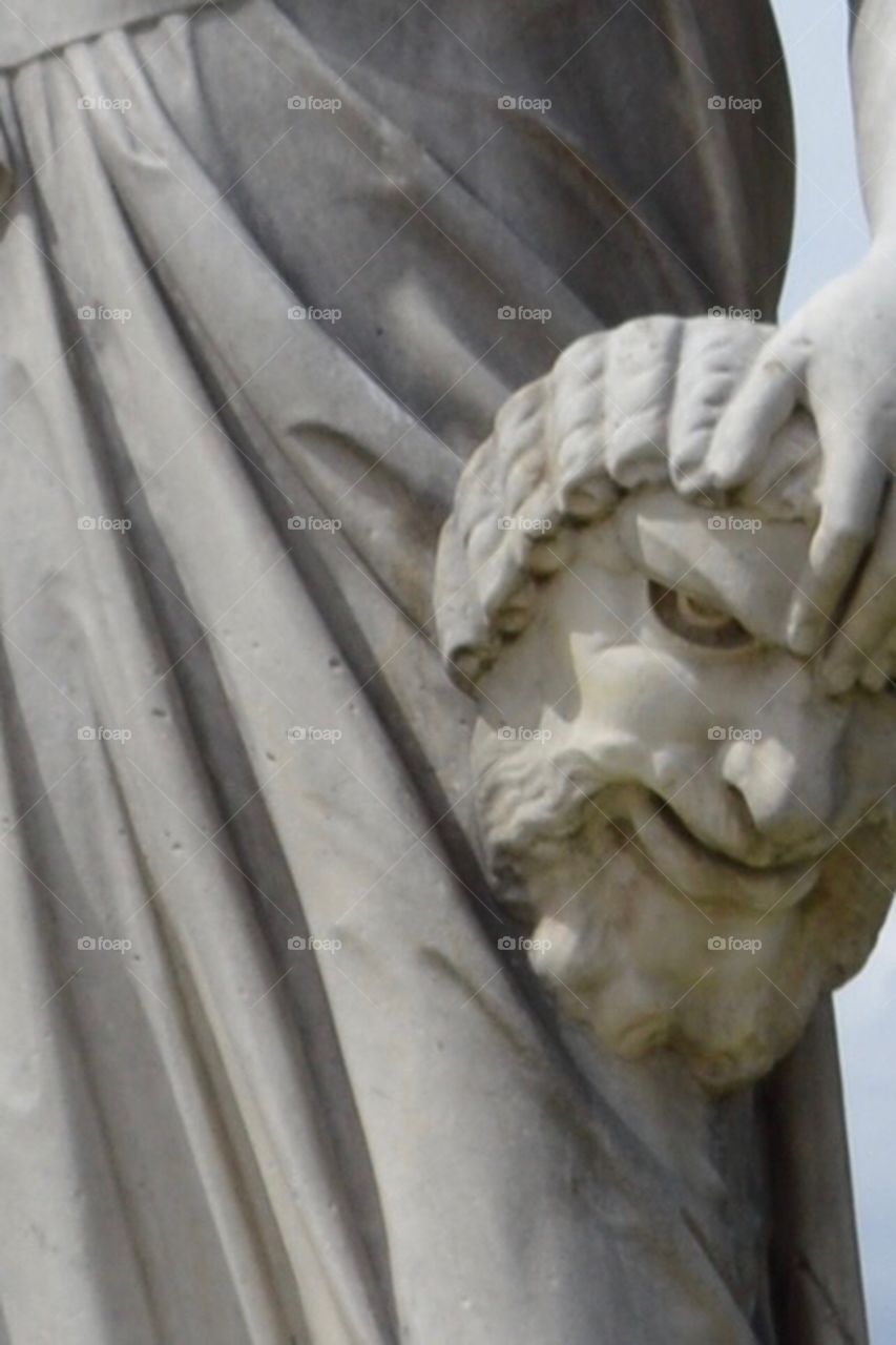 Woman statue holding mans head