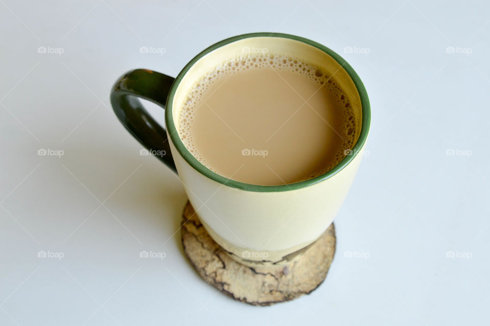 Mug of coffee on a natural wooden coaster