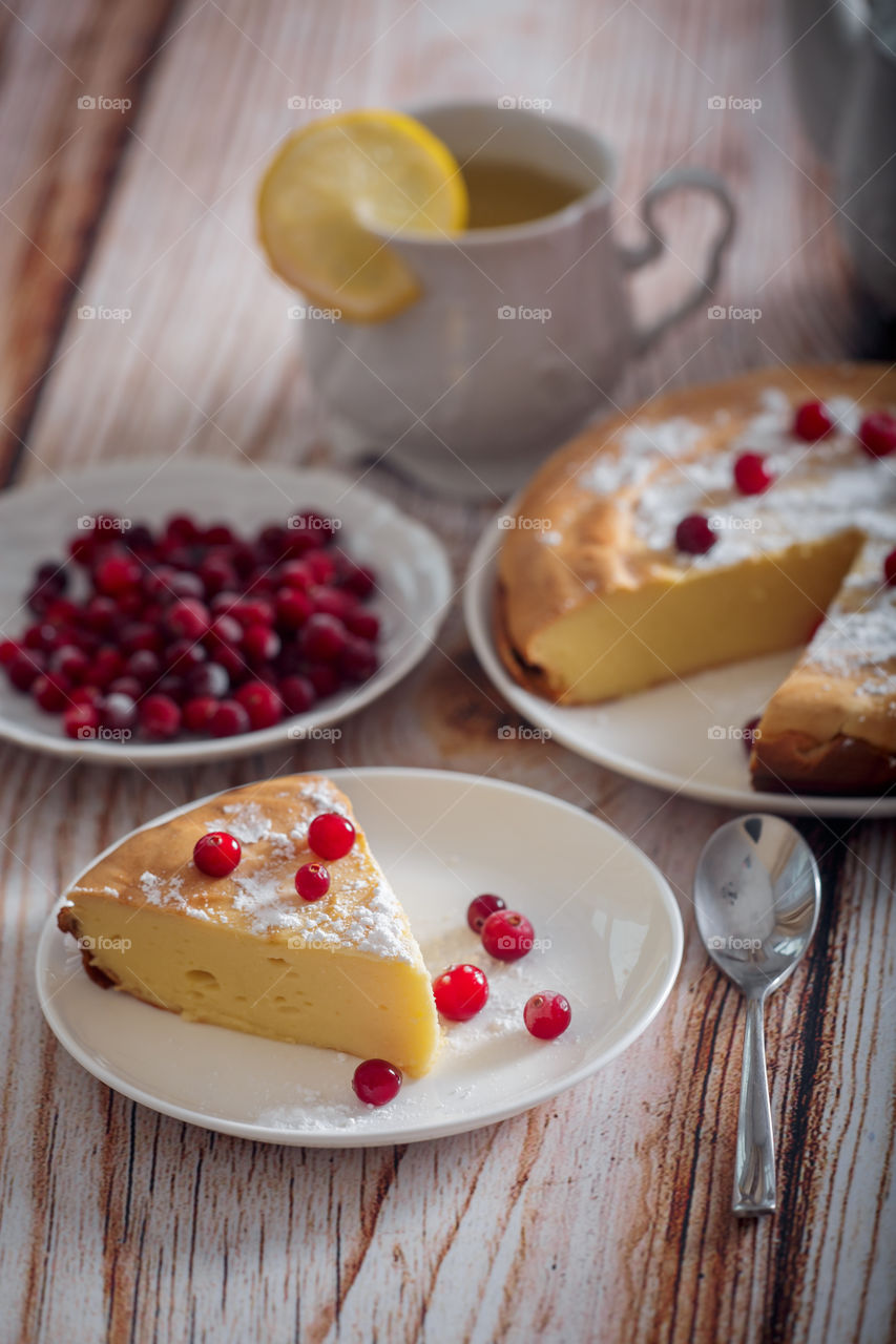 Cheesecake with cranberries and sugar on wooden background 