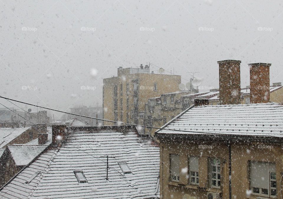 Snow falling on the roofs of the city