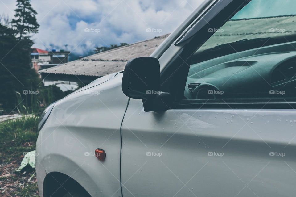 A side angle shot of front side of a car in the rain